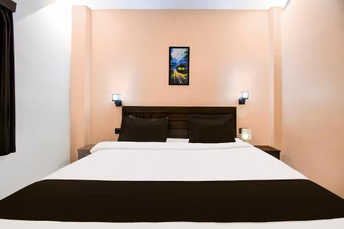 a bedroom with a large white bed with black pillows at Hotel O M H Club And Resorts in Rānchī