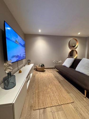 a living room with a black couch and a large screen tv at Departamento en Ciudad de México in Mexico City