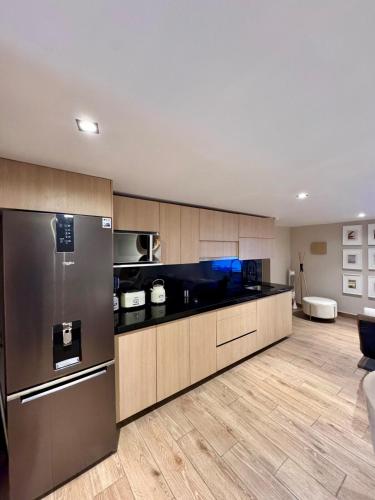 a kitchen with stainless steel appliances and wooden cabinets at Departamento en Ciudad de México in Mexico City
