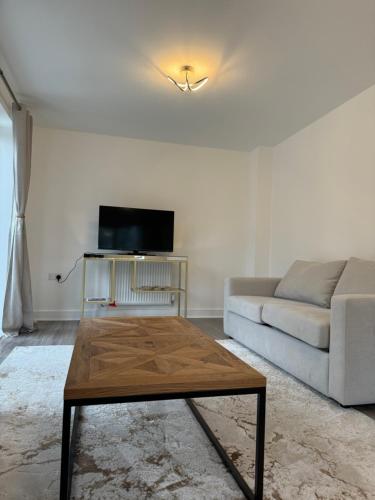 a living room with a couch and a coffee table at 3 Bedroom Brand New Whiteley Home with Hot Tub in Botley
