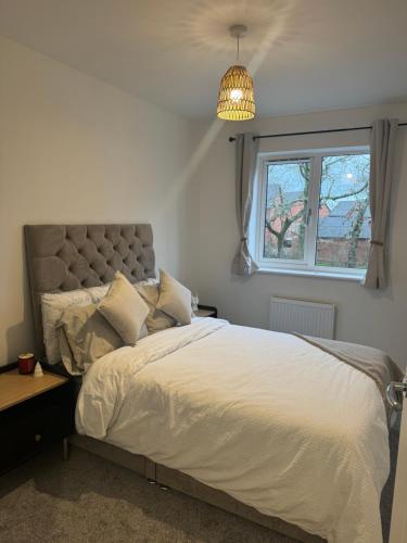 a bedroom with a bed and a window at 3 Bedroom Brand New Whiteley Home with Hot Tub in Botley