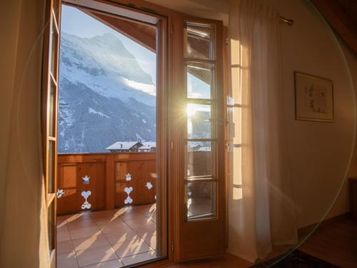 a room with a window with a view of a mountain at Orion - Luxuriöse Duplex Wohnung in Grindelwald in Grindelwald