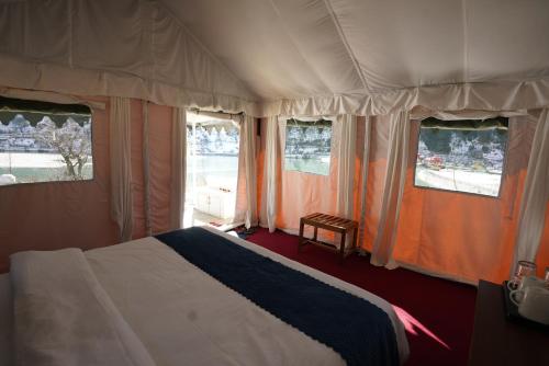 a bedroom with a bed and two windows and a bed sidx sidx sidx at The Kamru Riverside Camps and Resorts in Sāngla
