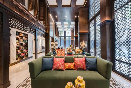 a living room with a green couch with colorful pillows at The Base Central Phuket-C54BS in Phuket Town