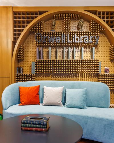 a blue couch with pillows and a table in a room at Rosemay Hotel near London Heathrow Airport in Hayes