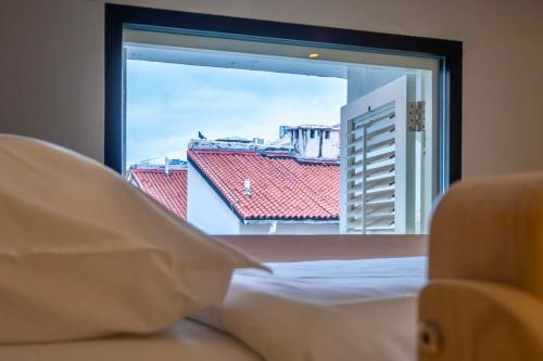 a bedroom with a window with a view of a building at Rest Chinatown Hotel in Singapore