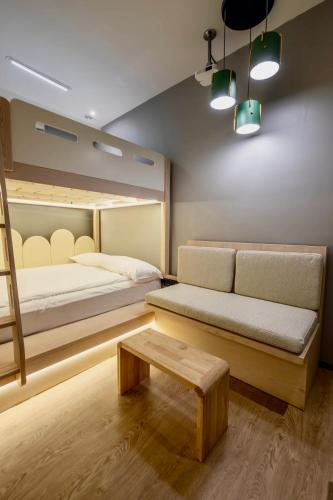 a room with a bed and a couch and a table at Rest Chinatown Hotel in Singapore