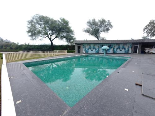 a swimming pool with blue water in front of a building at Neelam Orchid in Kānpur