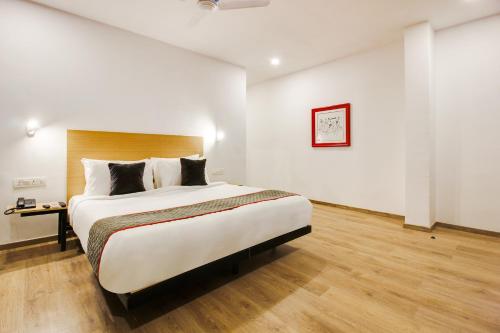 a bedroom with a large bed and a table at Super townhouse moosapet Rcc Prime in Hyderabad