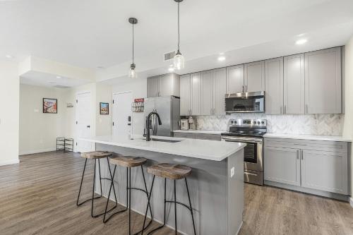 a kitchen with white cabinets and a kitchen island with bar stools at Here Comes the Sun condo in Atkinville