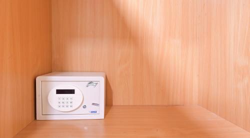 a microwave in a room with a wooden wall at Hotel Royale Hills By RSP Vista Hotels & Resorts in Rishīkesh