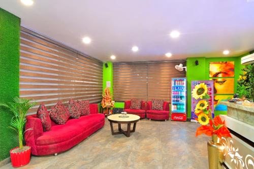 a living room with red couches and a table at Hotel Royale Hills By RSP Vista Hotels & Resorts in Rishīkesh