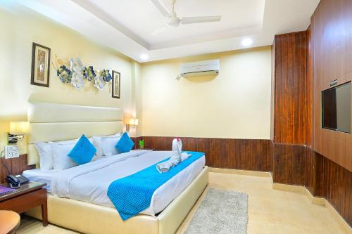 a bedroom with a bed with a blue blanket and a tv at Hotel Royale Hills By RSP Vista Hotels & Resorts in Rishīkesh