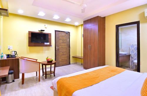 a hotel room with a bed and a table and a kitchen at Hotel Royale Hills By RSP Vista Hotels & Resorts in Rishīkesh