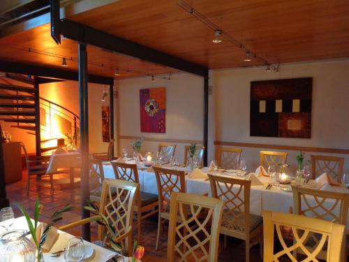 a dining room with white tables and chairs with lights at Salischer Hof in Schifferstadt