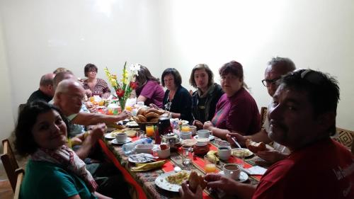un grupo de personas sentadas en una mesa comiendo comida en Vista Waynapata 1 23 en Machu Picchu