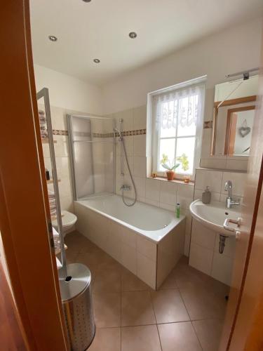 a bathroom with a tub and a toilet and a sink at Gemütliche 2 Zimmerwohnung in Wuppertal