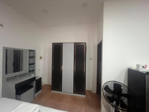 Habitación con cama, TV y silla. en Nine Blue 4 BD Villa, en Pattaya South