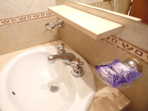 lavabo blanco en el baño con espejo en Apartamentos Güemes - Monoambientes en Bahía Blanca