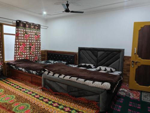 a bedroom with a large bed and a window at Global Albaik Holidays in Srinagar