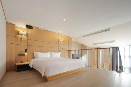 重庆The Boutique Hotel with Authentic Antique Collection & Suzhou Garden的卧室里有一张白色的大床和一扇窗户