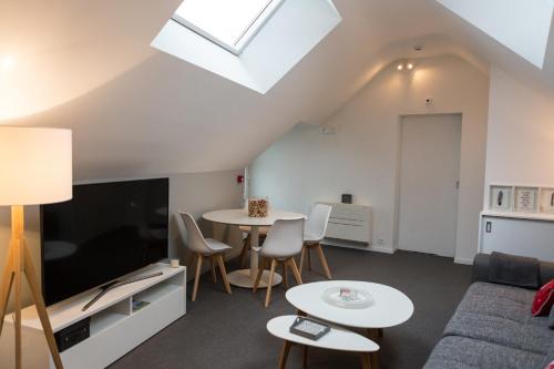 a living room with a couch and two tables and a tv at Le Coin Cocoon in Aywaille
