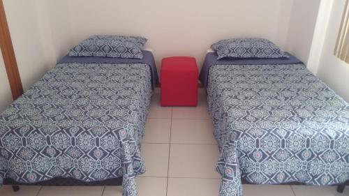 two beds in a room with a red box between them at Apartamento Manaus Arena da Amazonia in Manaus