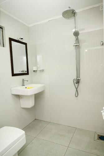 a white bathroom with a sink and a mirror at Villa Baranzio in Tangalle