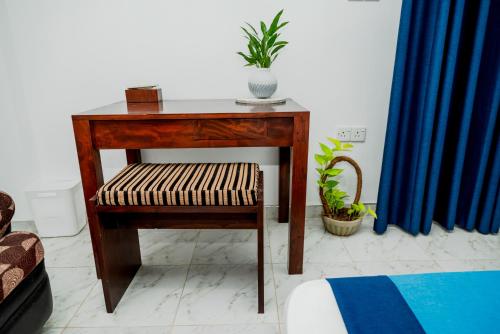 a wooden table with a chair and a plant on it at Villa Baranzio in Tangalle