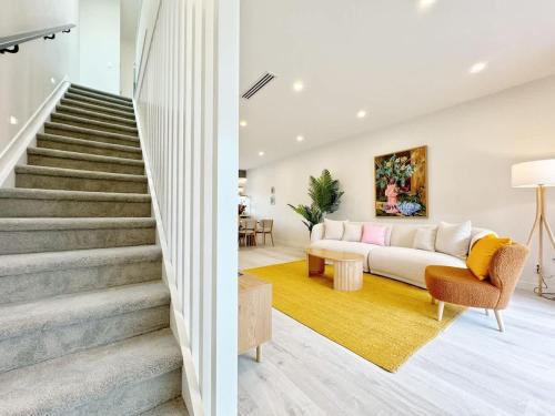a living room with a couch and stairs at A Home Away From Home - Luxury 4Beds ASB Showgrounds & Cornwall Park in Auckland