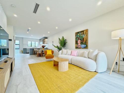 uma sala de estar com um sofá branco e uma mesa em A Home Away From Home - Luxury 4Beds ASB Showgrounds & Cornwall Park em Auckland