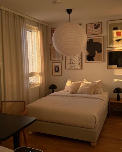 a bedroom with a bed and a pendant light at Cozy Top-Floor Studio in Turku - Near City Center in Turku