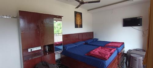 a bedroom with a bed and a tv on the wall at Glasshouse Retreat by The Jungle stay groups in Vālpārai