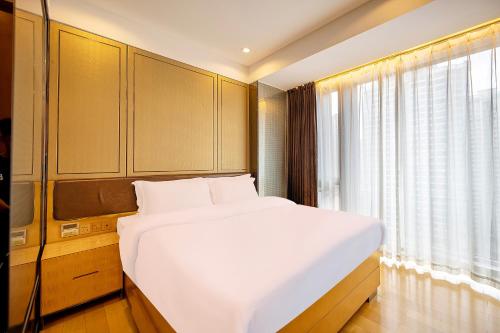 a bedroom with a large white bed and a window at Vaperse Hotel Guangzhou Zhujiang New Town - Free Shuttle Bus & Registration Counter During Canton Fair in Guangzhou