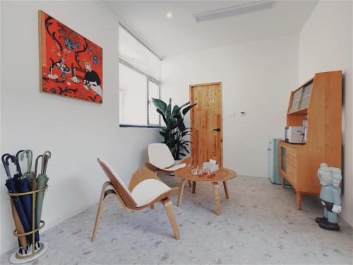 Suzhou Xugusu B&B-Guanqian Street Pingjiang Road Branch في سوتشو: غرفة معيشة مع كرسيين وطاولة