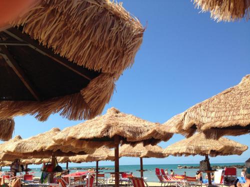 un grupo de sombrillas de paja en una playa en Holiday Dreams, en Francavilla al Mare