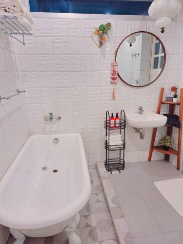 a white bathroom with a tub and a sink at Noosa海岸行館 in Fengbin