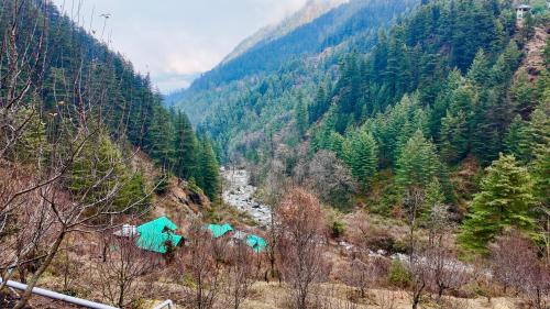 a blue house on the side of a mountain at The Luxe Cascades JIbhi in Jibhi