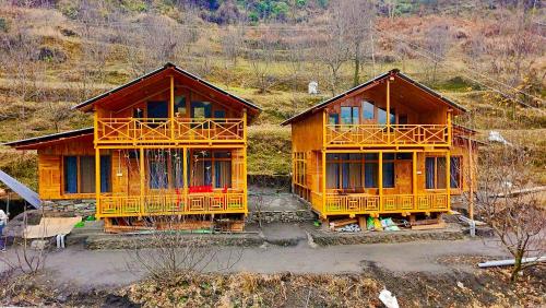 two wooden houses sitting on top of a hill at The Luxe Cascades JIbhi in Jibhi