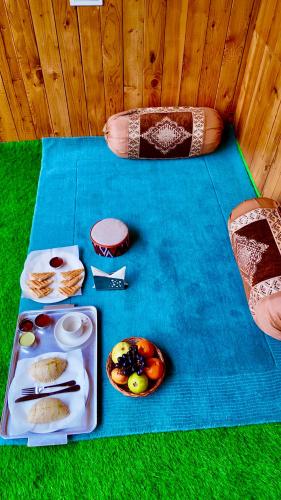 a table with plates of food on a blue table cloth at The Luxe Cascades JIbhi in Jibhi