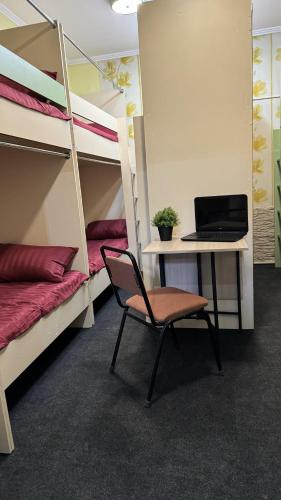 a room with bunk beds and a desk with a laptop at Лучший хостел Алматы - Масанчи in Almaty