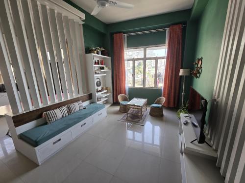 a living room with green walls and a couch at Greenview City Stay Apartments in Āīzawl