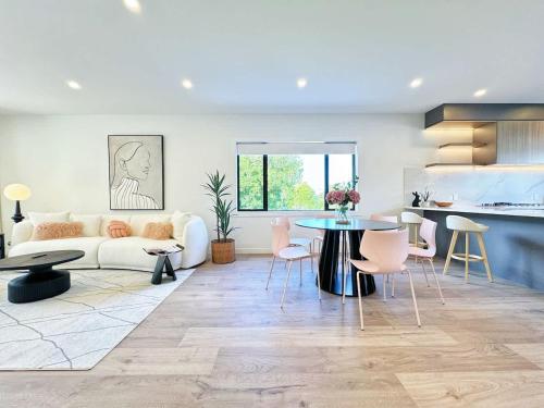 a living room with a white couch and a table at Luxury 4Bedroom Townhouse in Central Greenlane - ASB Showgrounds & Cornwall Park in Auckland