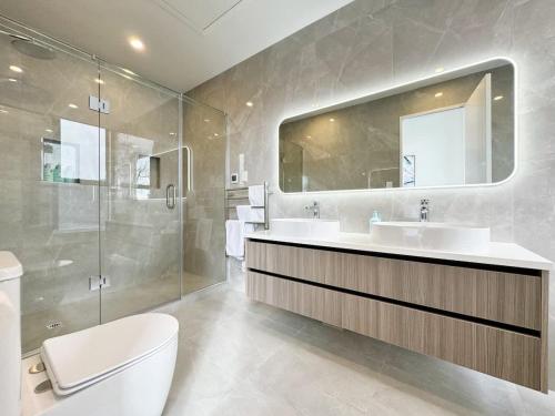 a bathroom with a toilet and a sink and a mirror at Luxury 4Bedroom Townhouse in Central Greenlane - ASB Showgrounds & Cornwall Park in Auckland