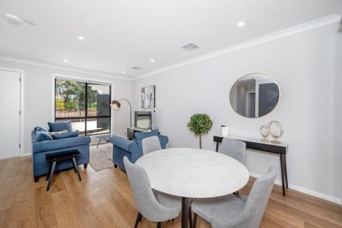 a living room with a table and chairs at Whispering Vines in McLaren Vale