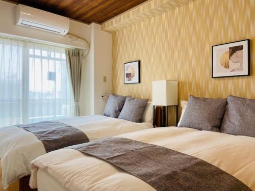 a bedroom with two beds and a window at First Tennoji East 601 ファースト天王寺東 601 in Osaka