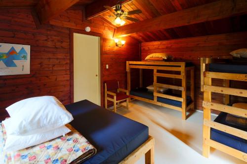 a room with a bed and a desk in a cabin at HI Athabasca Falls - Hostel in Jasper