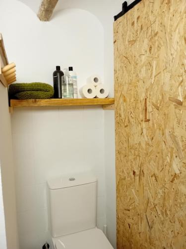 a bathroom with a toilet and a wooden door at Calderona Tiny house in Segorbe