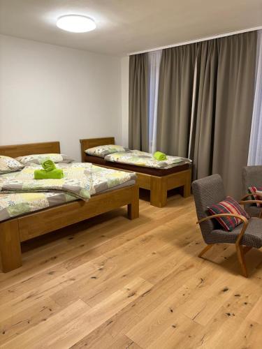 a room with two beds and a table and a chair at Apartmány Skalica in Skalica