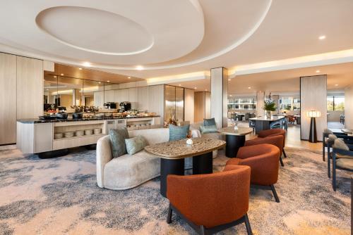 a living room with a couch and a table and chairs at Pan Pacific Perth in Perth